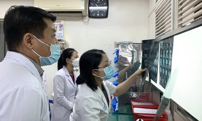 Bác sĩ Trần Thị Mai Linh hội chẩn cùng các đồng nghiệp, chuẩn bị cho một ca phẫu thuật thần kinh sọ não. (Ảnh: Đinh Hằng/TTXVN)